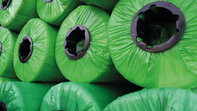 Rolls of non-woven geotextile wrapped in green plastic 