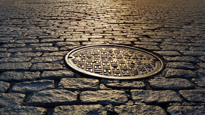 old manhole cover cobbled street