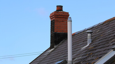drainage soil vent pipe on a roof near chimney