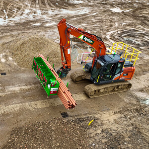 Agetur UK excavator moving SiteStak drainage workstation on a construction site drone photo