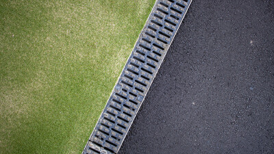 linear channel drain between tarmac and astroturf surfaces