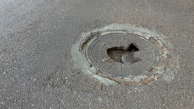 broken manhole cover smashed in road